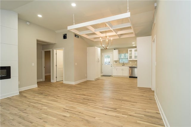 unfurnished living room with a tiled fireplace, beamed ceiling, light hardwood / wood-style floors, and coffered ceiling