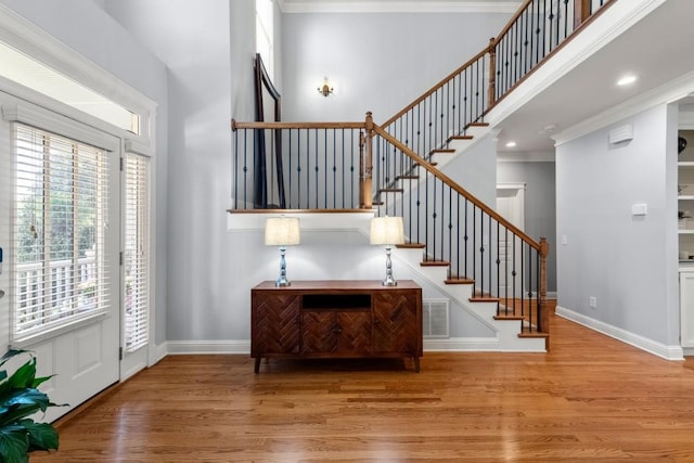 entrance foyer with baseboards, wood finished floors, and stairs