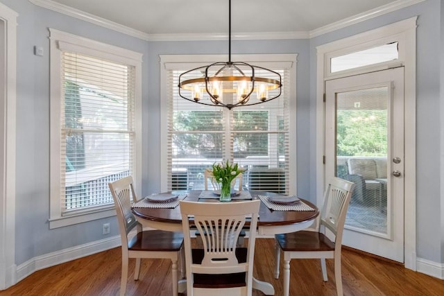 dining space with baseboards, wood finished floors, and an inviting chandelier