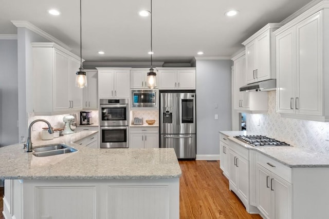 kitchen with a sink, appliances with stainless steel finishes, white cabinets, a peninsula, and under cabinet range hood