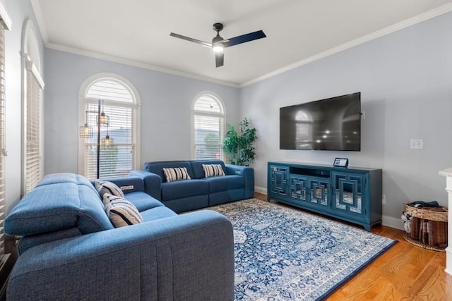 living room with wood finished floors, ornamental molding, baseboards, and ceiling fan