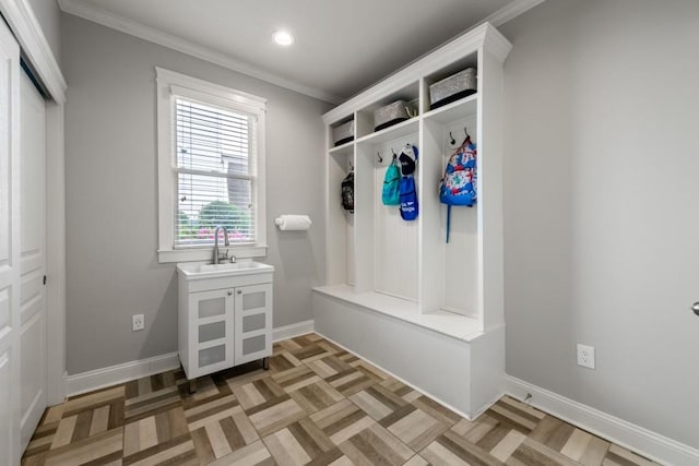 mudroom with recessed lighting, crown molding, baseboards, and a sink