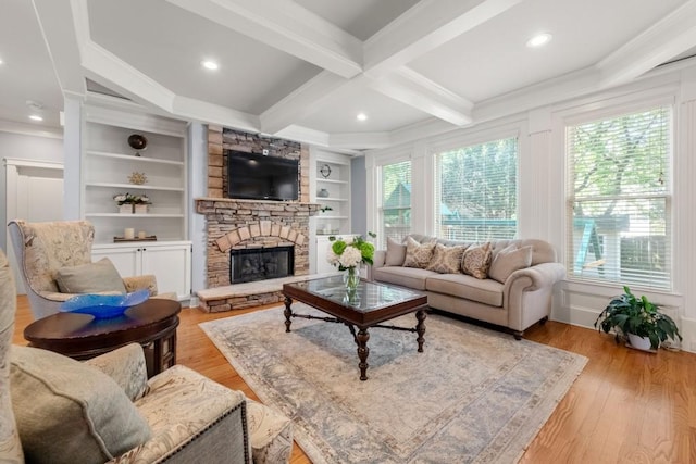 living area featuring crown molding, light wood finished floors, beamed ceiling, a fireplace, and coffered ceiling