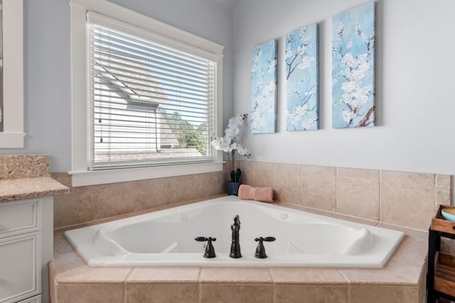 full bath featuring a garden tub and vanity