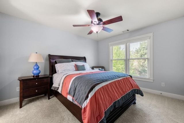 carpeted bedroom featuring baseboards, a ceiling fan, and visible vents
