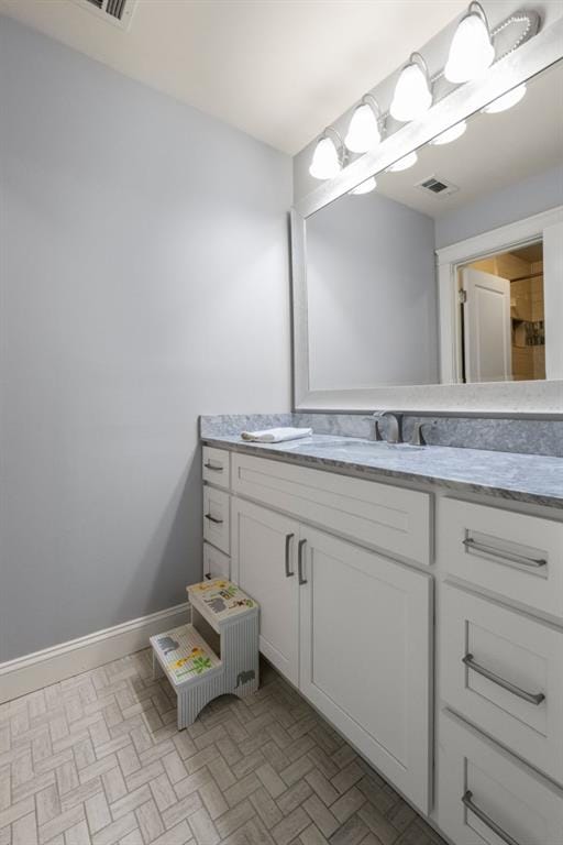 bathroom with baseboards, visible vents, and vanity