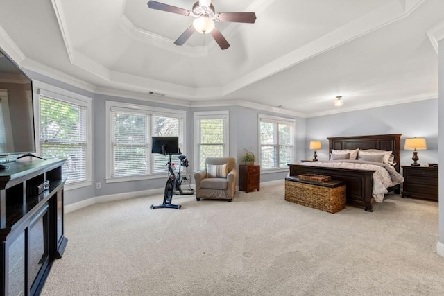 bedroom featuring a tray ceiling, baseboards, ceiling fan, crown molding, and carpet floors