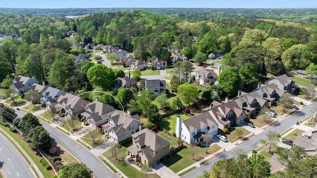 drone / aerial view featuring a residential view and a wooded view
