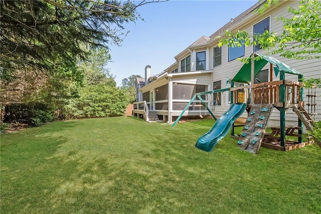 view of jungle gym featuring a sunroom and a yard