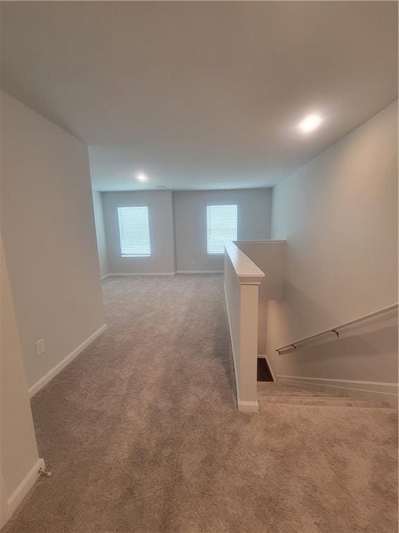 below grade area featuring baseboards and carpet flooring