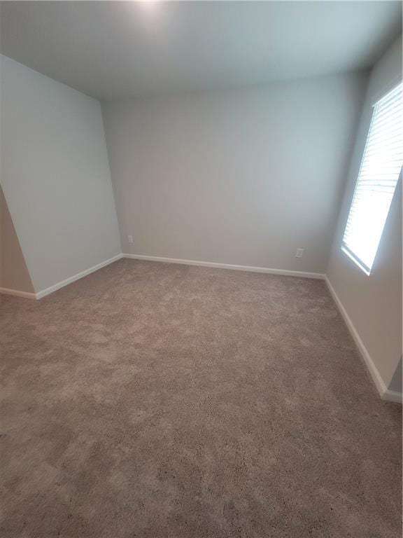 unfurnished room with carpet floors and baseboards
