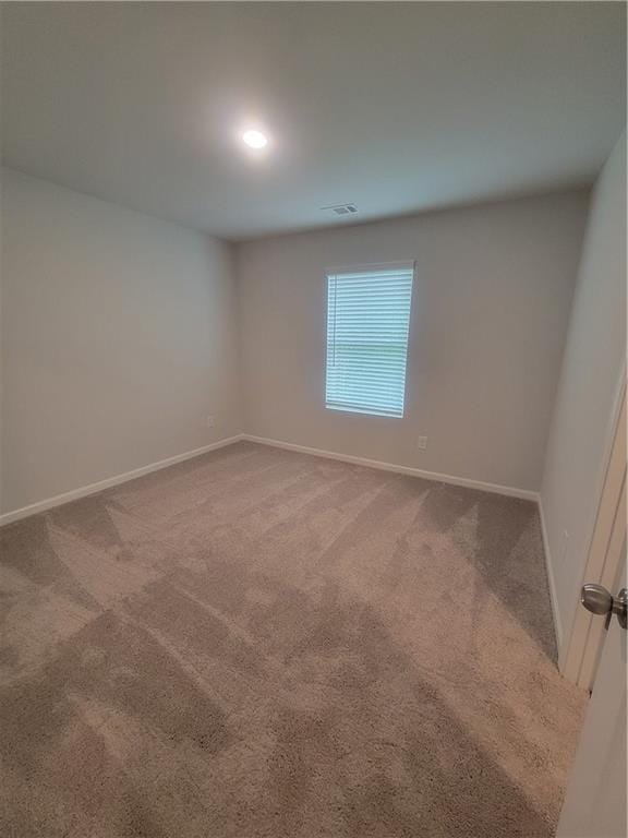 empty room featuring carpet flooring, recessed lighting, baseboards, and visible vents