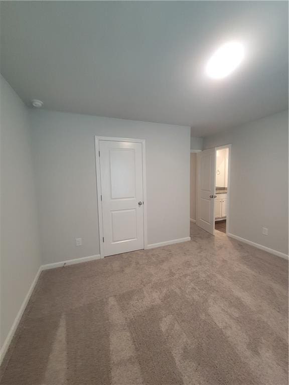 empty room featuring baseboards and carpet floors