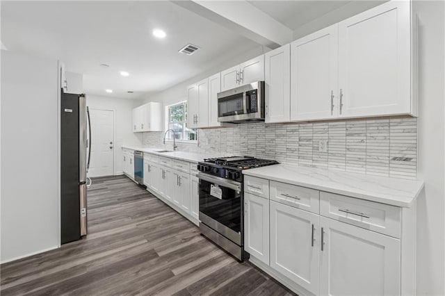 1978 Ethel Ln, Decatur, GA 30032 - kitchen with appliances with stainless steel finishes, white cabinetry, dark wood-type flooring, recessed lighting, and decorative backsplash