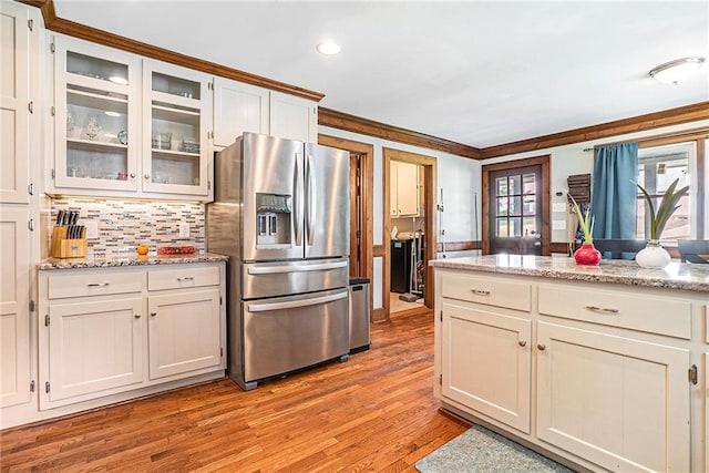 3392 Inns Brook Way, Snellville, GA 30039 - kitchen featuring stainless steel fridge, light wood-style flooring, tasteful backsplash, crown molding, and glass insert cabinets