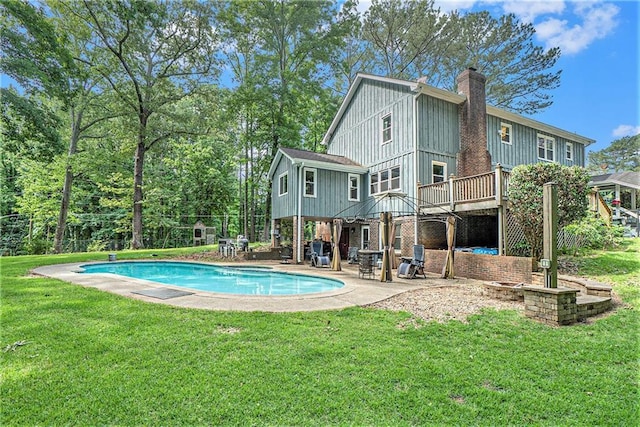 3392 Inns Brook Way, Snellville, GA 30039 - back of house with board and batten siding, a patio, an outdoor pool, a chimney, and a lawn