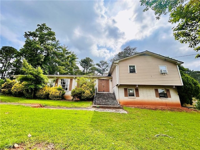 back of house with brick siding and a yard