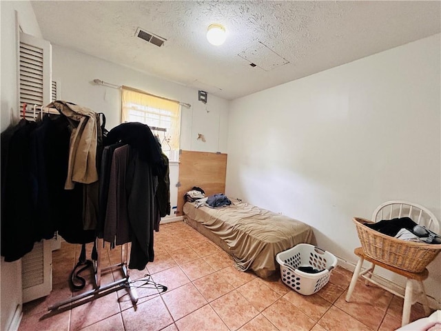 bedroom featuring a textured ceiling and light tile patterned floors