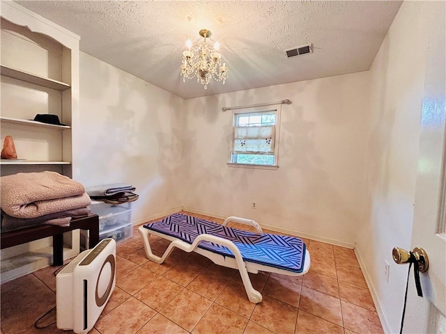 sitting room with a textured ceiling, built in features, a chandelier, baseboards, and light tile patterned floors