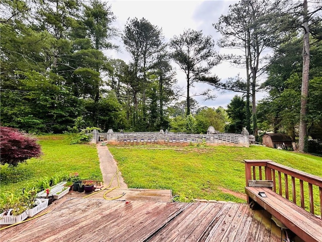 wooden terrace featuring a yard and view of wooded area