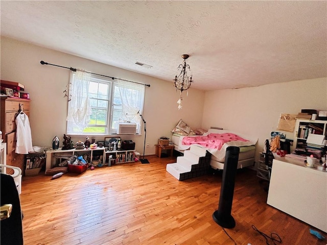 bedroom featuring wood finished floors and a textured ceiling