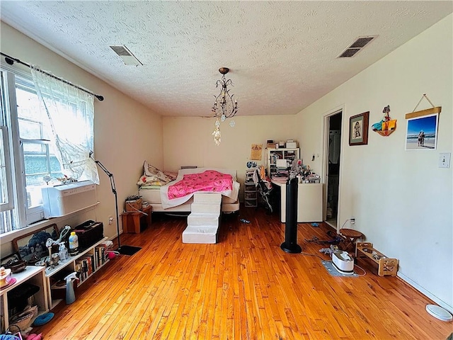 bedroom with hardwood / wood-style floors and a textured ceiling