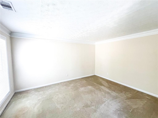 carpeted empty room with baseboards, ornamental molding, a wealth of natural light, and visible vents
