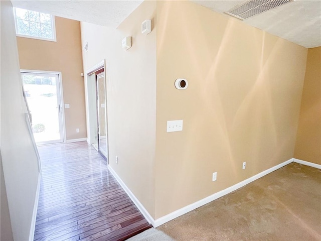 hall with baseboards and visible vents