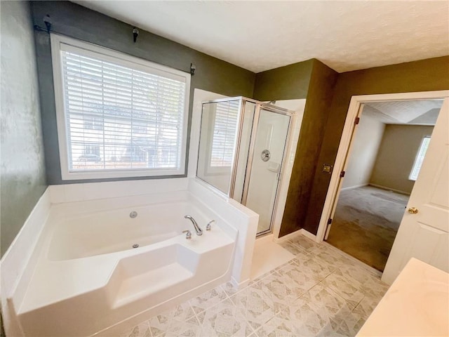 bathroom with tile patterned flooring, a wealth of natural light, a garden tub, and a stall shower