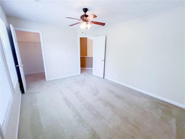 unfurnished bedroom with baseboards, a spacious closet, and carpet