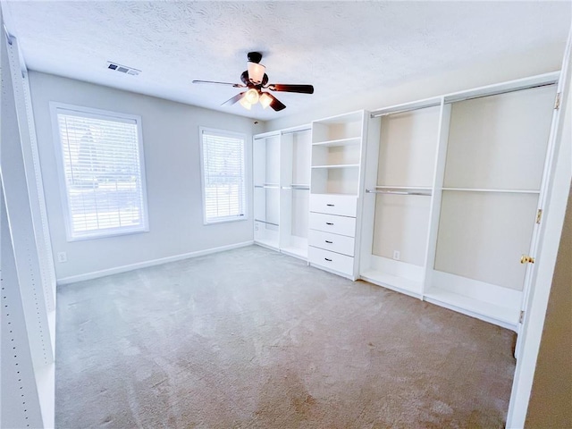 unfurnished bedroom featuring multiple closets, baseboards, carpet flooring, and visible vents