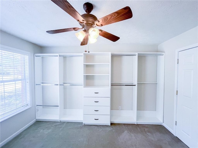 unfurnished bedroom with baseboards, carpet, a ceiling fan, and a textured ceiling