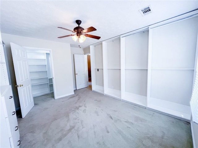 unfurnished bedroom featuring visible vents, a ceiling fan, baseboards, and light carpet
