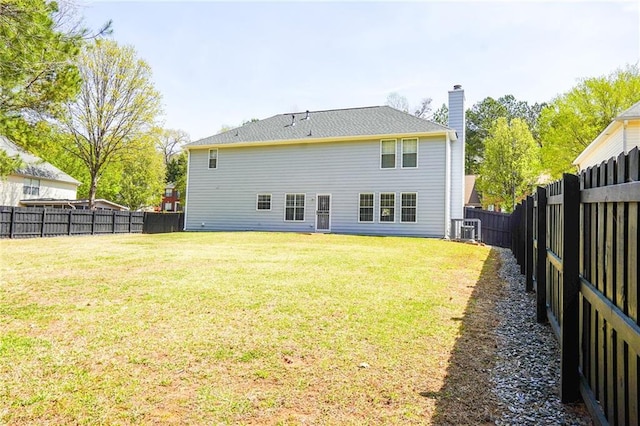 rear view of house with a yard, cooling unit, a chimney, and a fenced backyard