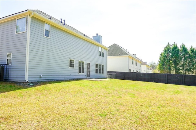 back of property with a yard, fence, a chimney, and central air condition unit