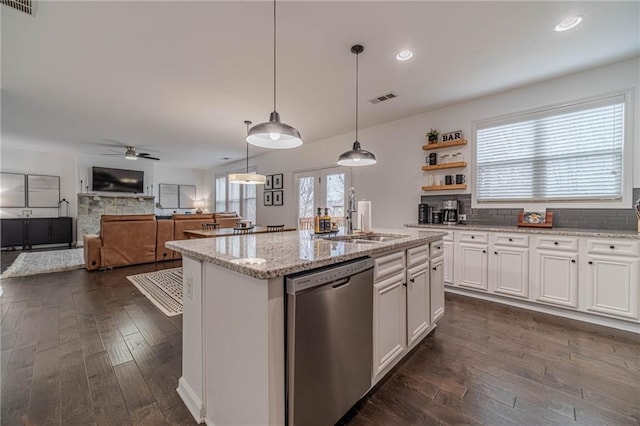 kitchen with sink, dishwasher, white cabinetry, light stone countertops, and decorative light fixtures