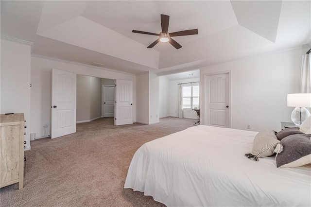 carpeted bedroom with a raised ceiling, ornamental molding, and ceiling fan