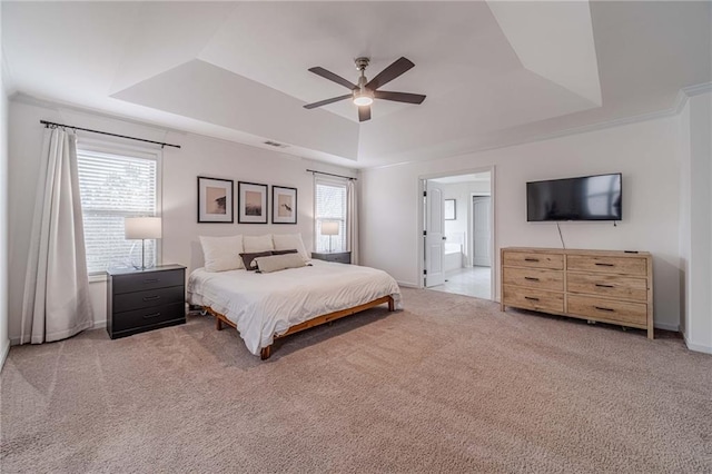 bedroom with a raised ceiling, light colored carpet, and multiple windows