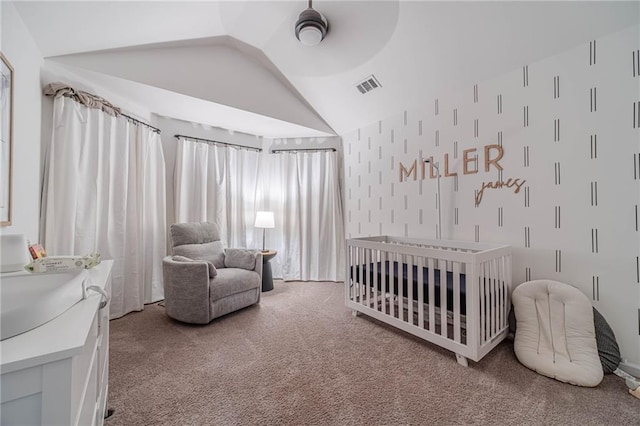 bedroom featuring vaulted ceiling, carpet floors, and a crib