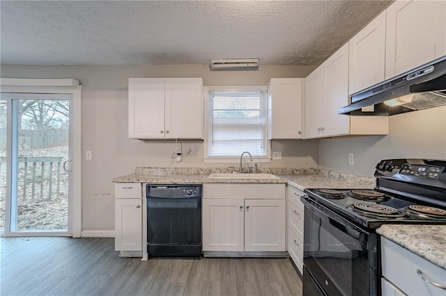 180 Sears Cir, Covington, GA 30016 - kitchen featuring sink, black appliances, light hardwood / wood-style floors, white cabinets, and light stone countertops
