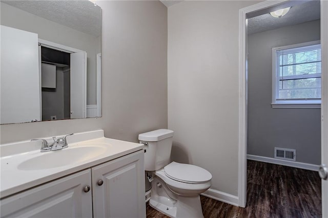 180 Sears Cir, Covington, GA 30016 - bathroom with hardwood / wood-style flooring, vanity, a textured ceiling, and toilet