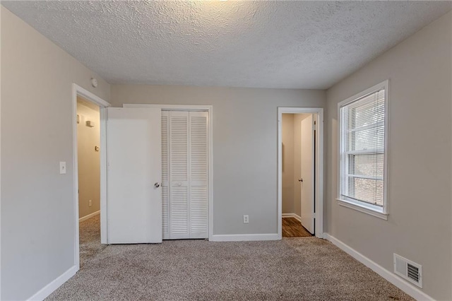 180 Sears Cir, Covington, GA 30016 - unfurnished bedroom with light carpet, a closet, and a textured ceiling