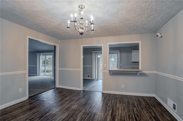 180 Sears Cir, Covington, GA 30016 - unfurnished dining area featuring an inviting chandelier, dark hardwood / wood-style floors, and a textured ceiling