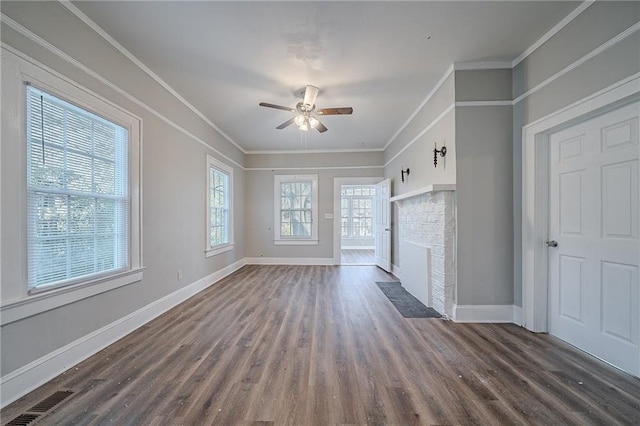 unfurnished living room featuring ceiling fan, ornamental molding, a fireplace, and dark hardwood / wood-style flooring