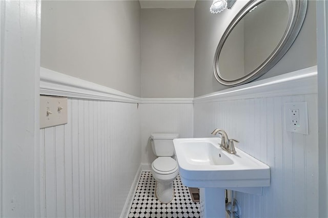 bathroom with toilet and wood walls