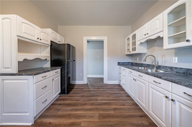 kitchen featuring dark hardwood / wood-style floors, sink, white cabinetry, and black fridge