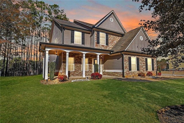 view of front of home with stone siding, board and batten siding, and a yard