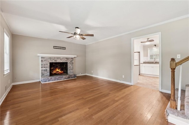 6010 White Oak Ct NW, Kennesaw, GA 31052 - unfurnished living room with a ceiling fan, hardwood / wood-style flooring, a brick fireplace, stairway, and crown molding