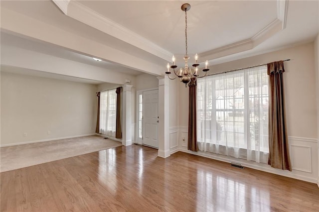 interior space featuring wood-type flooring, a tray ceiling, plenty of natural light, and an inviting chandelier