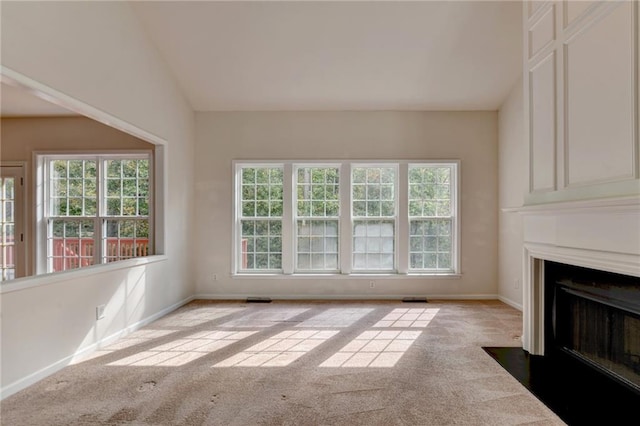 unfurnished living room featuring vaulted ceiling and light colored carpet